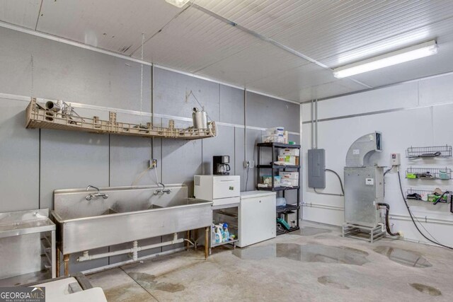 garage with refrigerator, electric panel, and sink