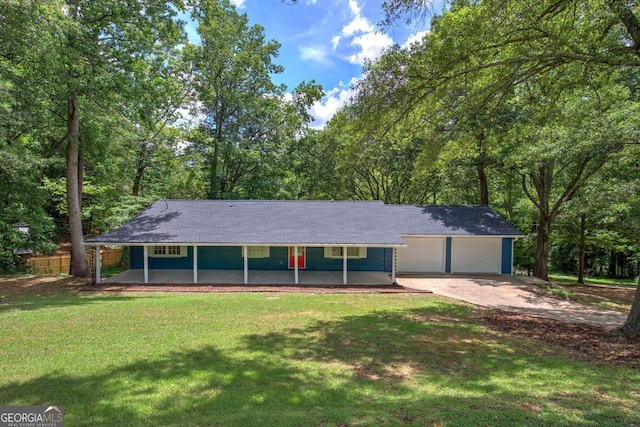 view of front of home featuring a front yard, covered porch, and a garage