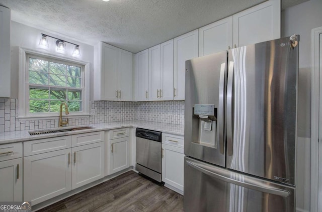 kitchen with white cabinetry, dark hardwood / wood-style flooring, stainless steel appliances, tasteful backsplash, and sink