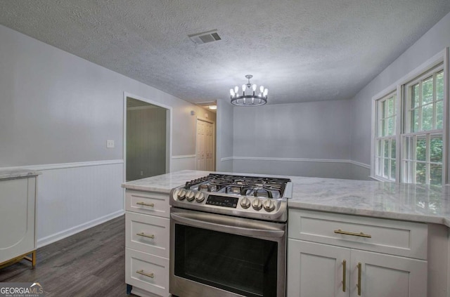 kitchen featuring a textured ceiling, light stone counters, gas stove, and white cabinetry