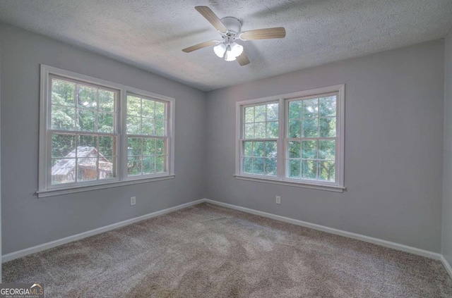 carpeted spare room featuring ceiling fan and a textured ceiling