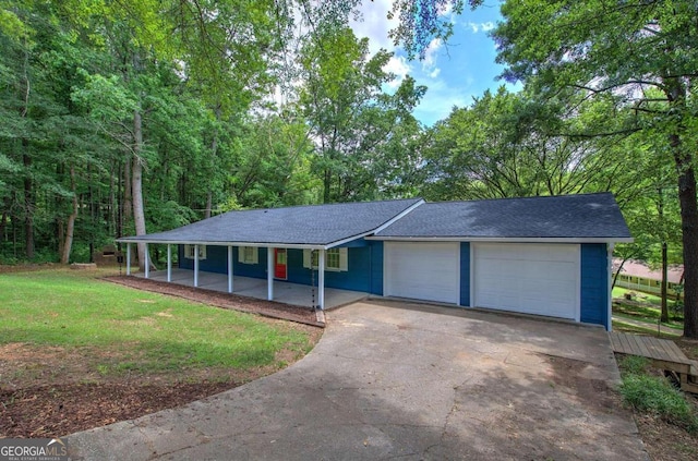 view of front of house featuring a front lawn, a patio, and a garage