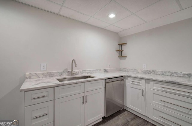 kitchen featuring a drop ceiling, dishwasher, sink, white cabinetry, and dark wood-type flooring