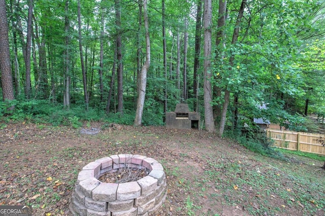 view of yard featuring an outdoor fire pit and exterior fireplace