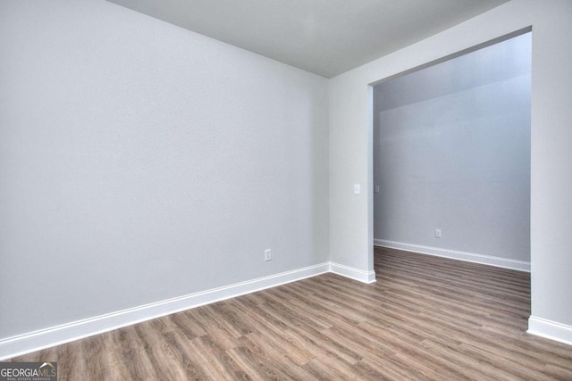 unfurnished room with wood finished floors and baseboards