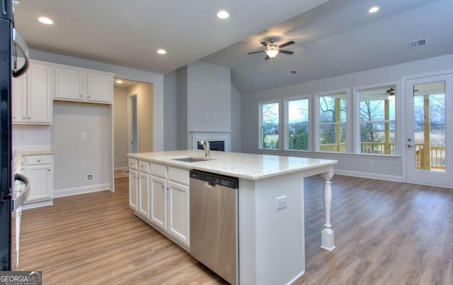 kitchen with stainless steel dishwasher, a sink, ceiling fan, light wood-style floors, and baseboards