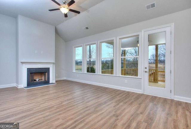 unfurnished living room featuring wood finished floors, visible vents, ceiling fan, and baseboards