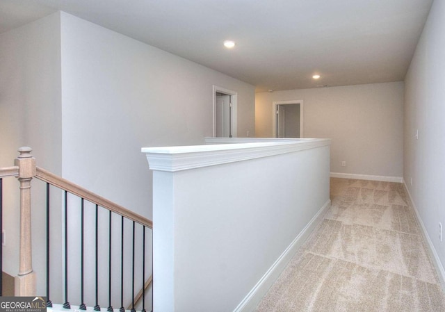hallway featuring baseboards, recessed lighting, an upstairs landing, and light colored carpet