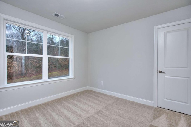carpeted empty room with visible vents and baseboards