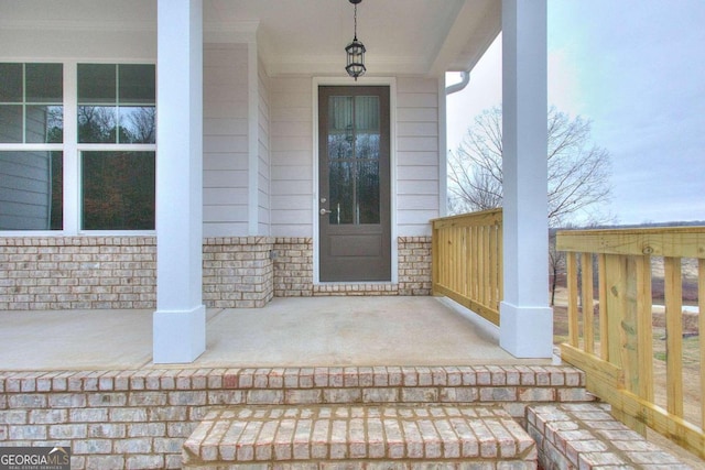 view of exterior entry featuring covered porch