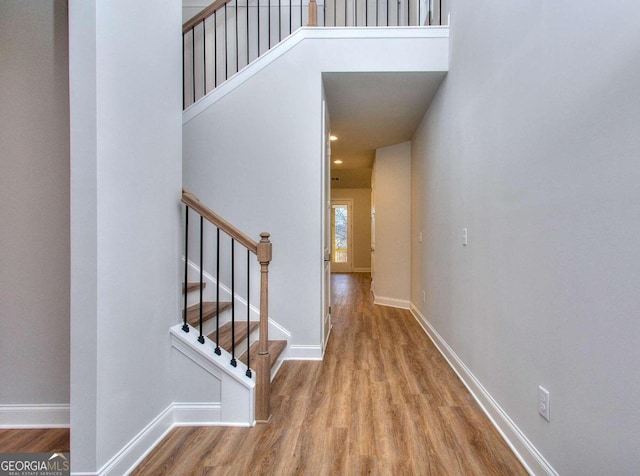 stairway with wood finished floors and baseboards