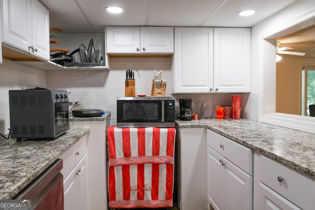 kitchen with tasteful backsplash, white cabinets, and appliances with stainless steel finishes