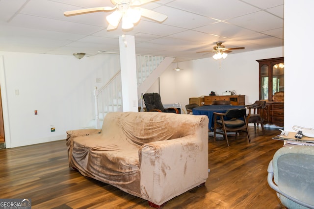 living room featuring a paneled ceiling, ceiling fan, and dark hardwood / wood-style flooring