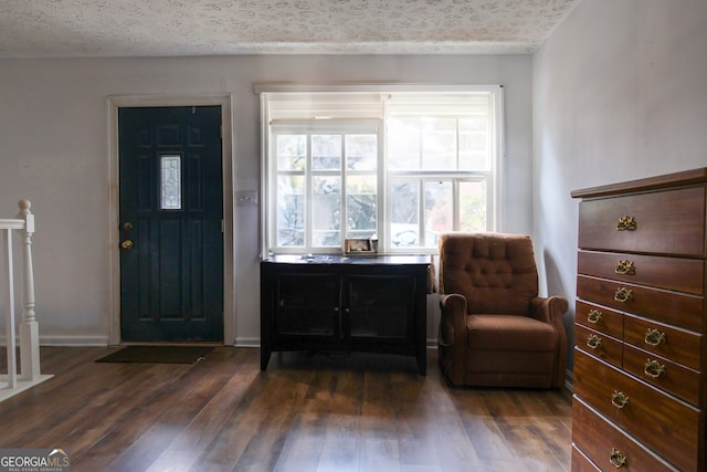 entrance foyer with dark hardwood / wood-style flooring and a textured ceiling