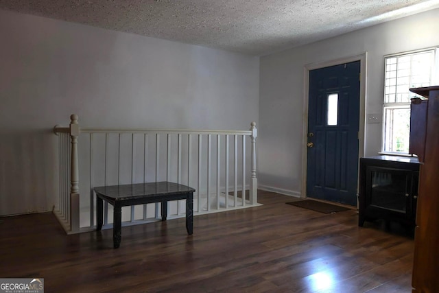 foyer with dark hardwood / wood-style floors and a textured ceiling