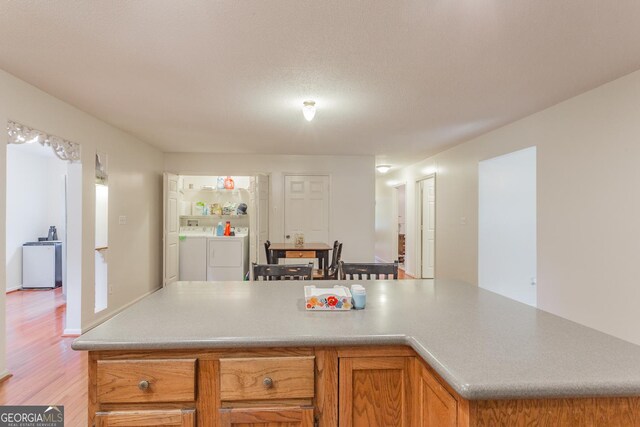 kitchen featuring washer and clothes dryer and light hardwood / wood-style floors