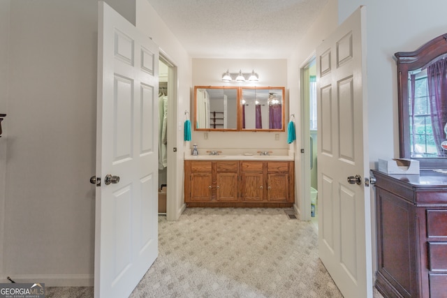 bathroom featuring a textured ceiling and double vanity