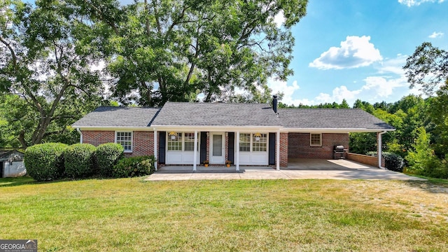 ranch-style house featuring a front yard, a carport, and covered porch