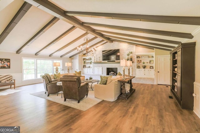 living room featuring hardwood / wood-style floors, vaulted ceiling with beams, and a brick fireplace