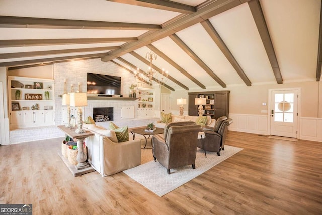 living room with vaulted ceiling with beams, a fireplace, hardwood / wood-style flooring, and built in features