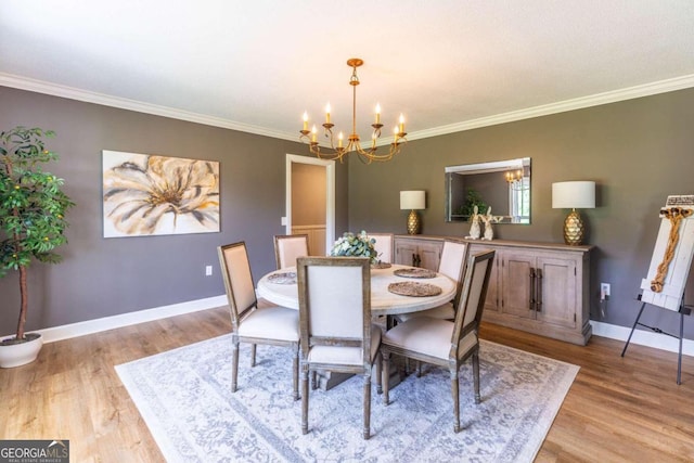 dining room with a chandelier, crown molding, and light wood-type flooring