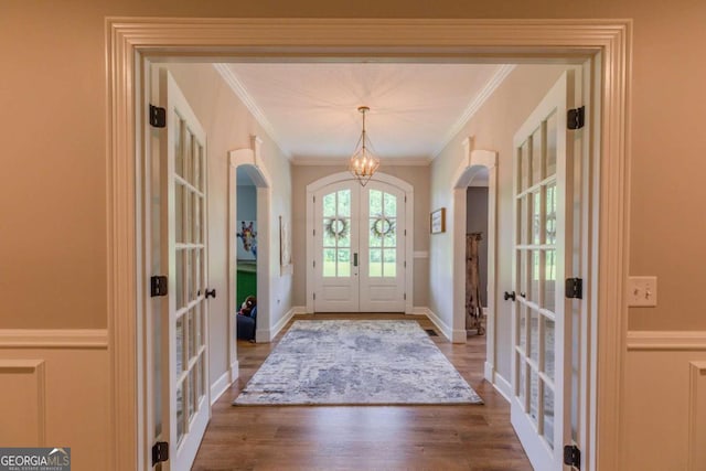 foyer entrance with crown molding, french doors, and hardwood / wood-style floors