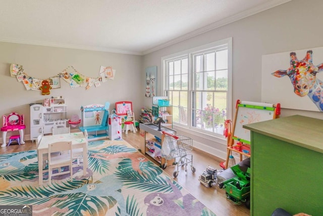 recreation room featuring ornamental molding, hardwood / wood-style flooring, and a wealth of natural light