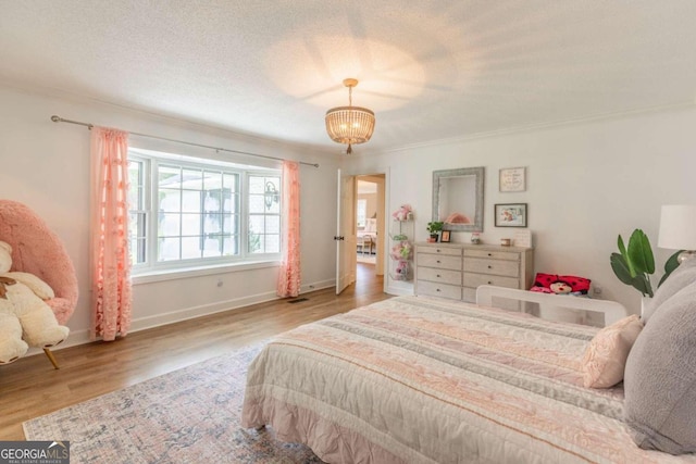 bedroom with a notable chandelier, ornamental molding, and hardwood / wood-style flooring