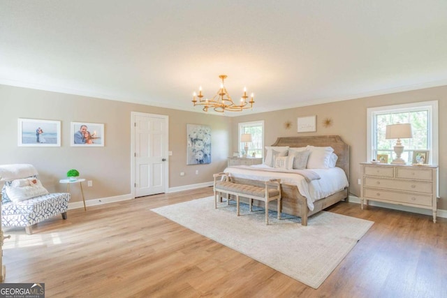 bedroom with crown molding, light hardwood / wood-style floors, multiple windows, and an inviting chandelier