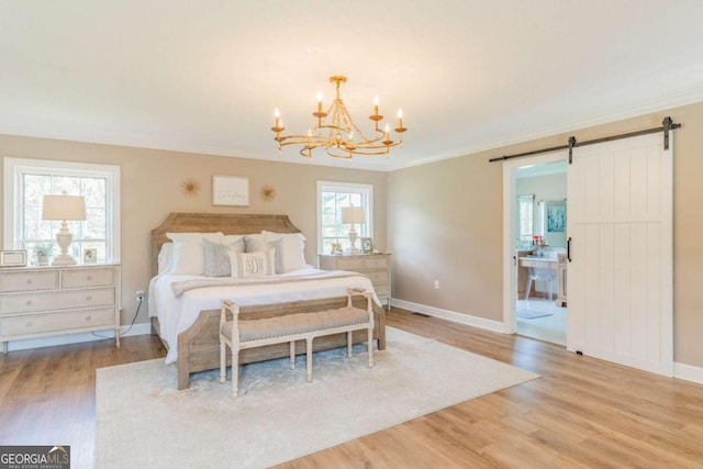 bedroom featuring a chandelier, light wood-type flooring, crown molding, and a barn door