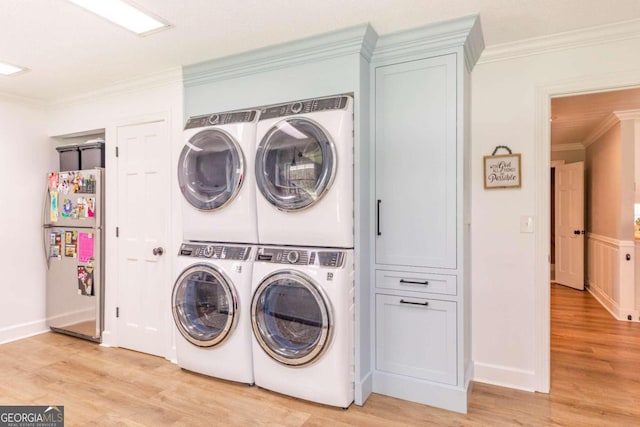 laundry area with stacked washer and dryer, light hardwood / wood-style flooring, crown molding, and washing machine and clothes dryer