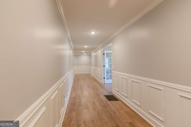 corridor featuring light hardwood / wood-style flooring and ornamental molding