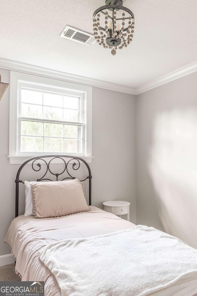 bedroom featuring ornamental molding and a textured ceiling