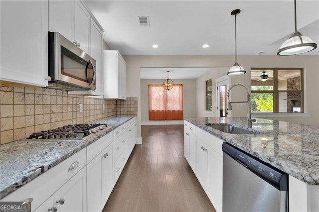 kitchen with white cabinets, appliances with stainless steel finishes, a healthy amount of sunlight, and sink