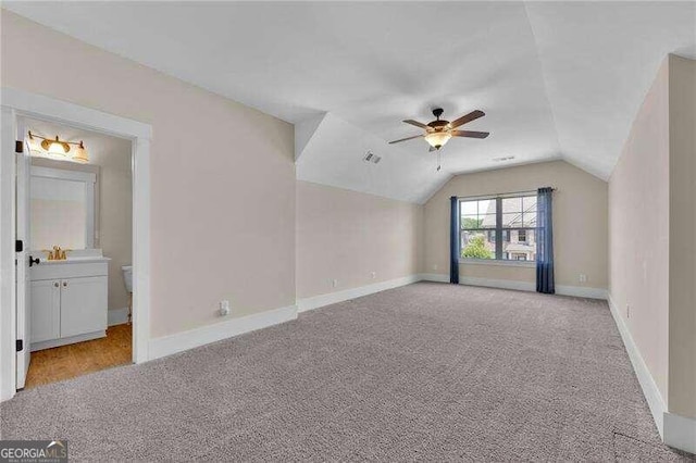 additional living space featuring light colored carpet, vaulted ceiling, and ceiling fan