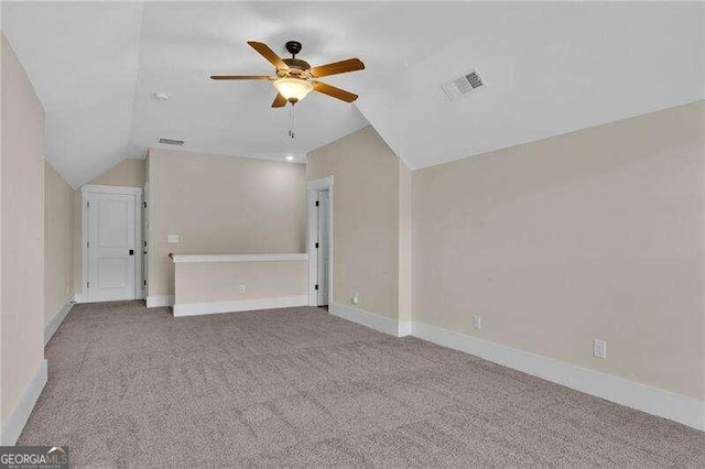 interior space with ceiling fan, light colored carpet, and vaulted ceiling