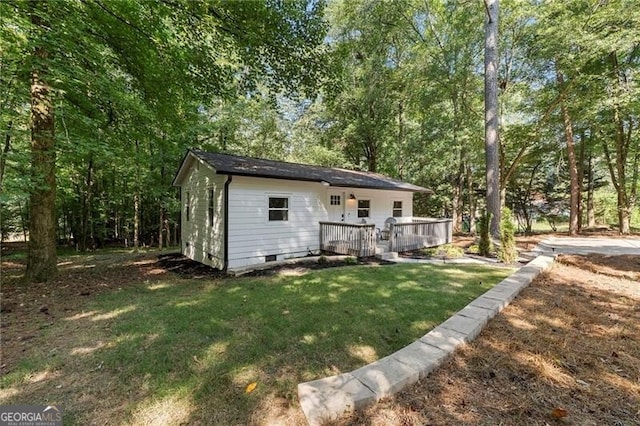 rear view of house with a lawn and a deck