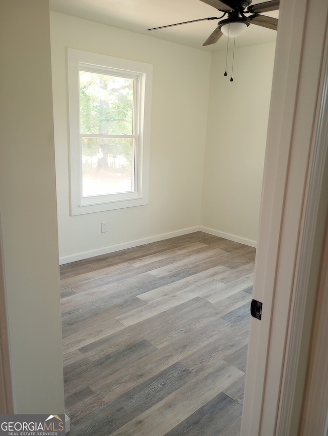 empty room with ceiling fan and light wood-type flooring