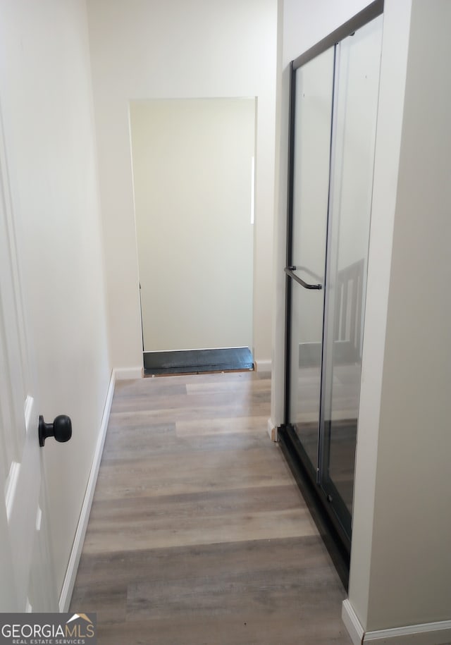 hallway with hardwood / wood-style flooring