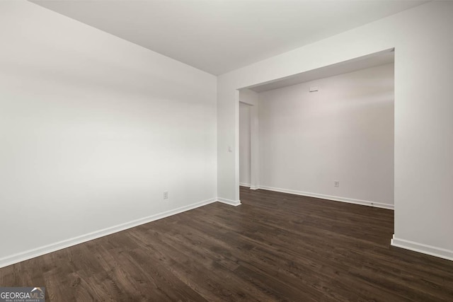 spare room with dark wood-type flooring