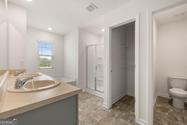 bathroom with toilet, vanity, and a shower with shower door