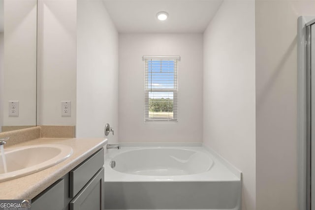 bathroom featuring vanity and a tub to relax in