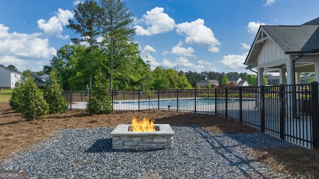 view of yard featuring a fenced in pool, a fire pit, and a patio area