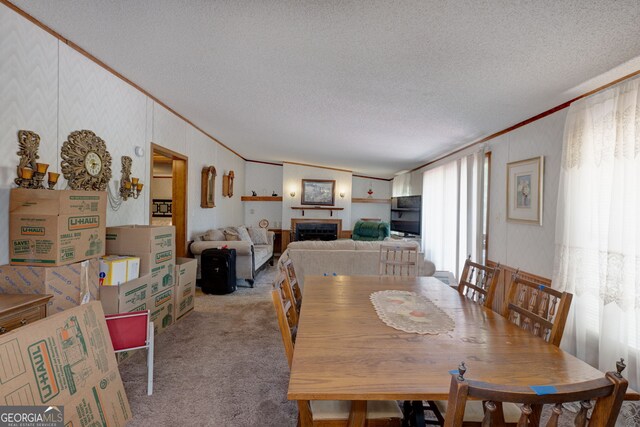 dining space with light carpet, ornamental molding, and a textured ceiling