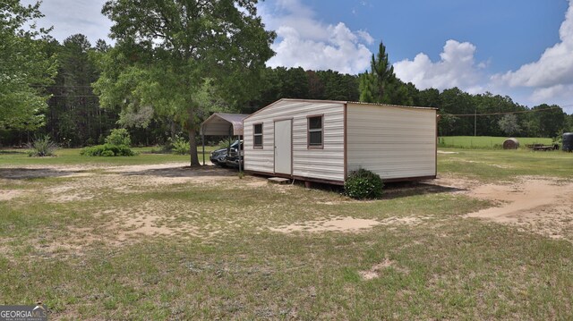 view of outbuilding with a yard and a carport