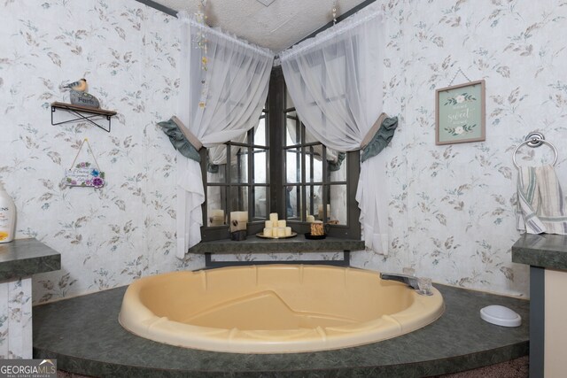 bathroom featuring a tub to relax in and a textured ceiling