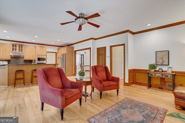 living room featuring light hardwood / wood-style floors, ornamental molding, and ceiling fan