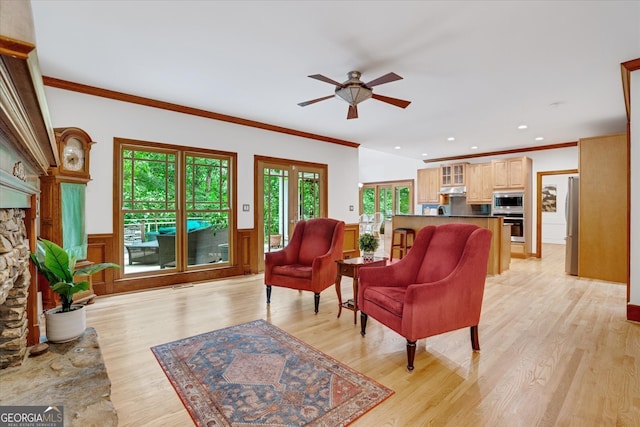 living room with a fireplace, a healthy amount of sunlight, light hardwood / wood-style flooring, and ceiling fan