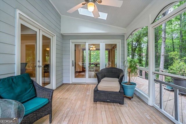 sunroom featuring lofted ceiling with skylight, french doors, and ceiling fan