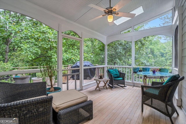 exterior space with vaulted ceiling with skylight and ceiling fan